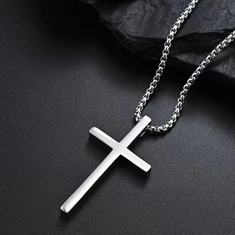 Silver cross necklace on a dark surface