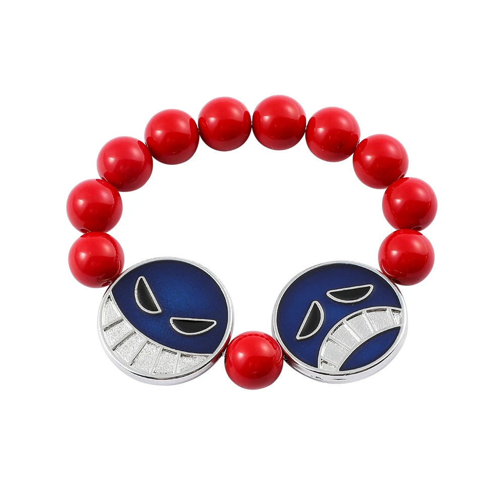 Bracelet with red beads and blue face-shaped charms on a white background