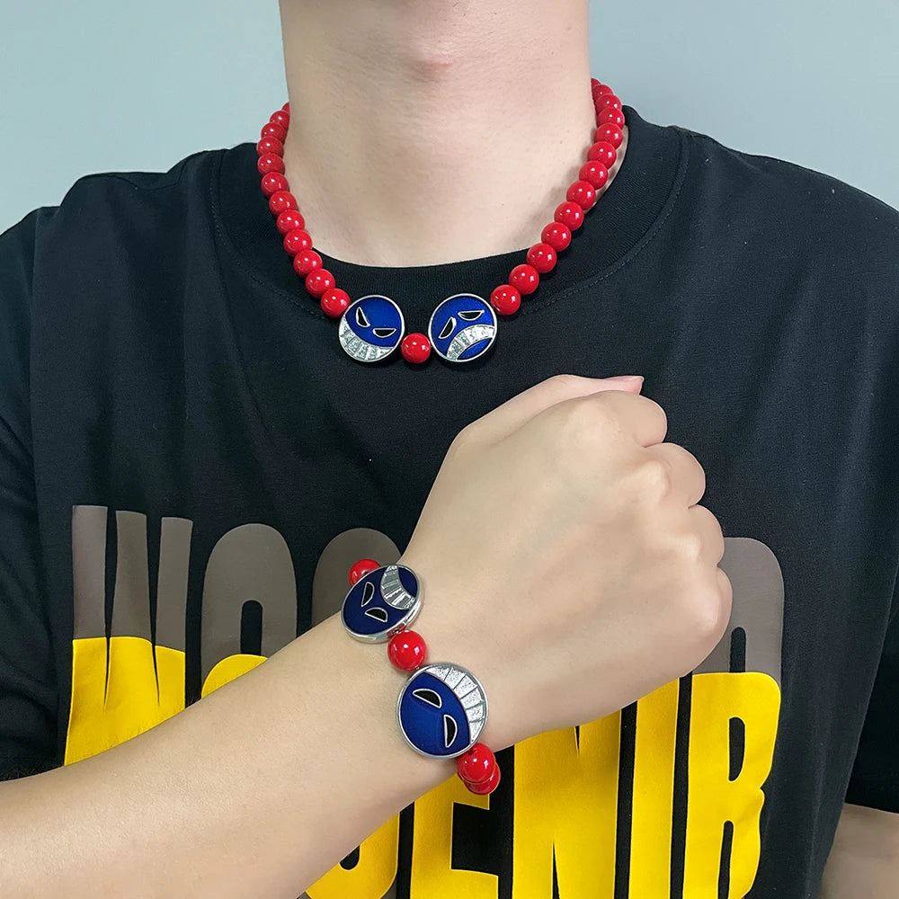 Person wearing a red beaded necklace and bracelet with blue and white circular charms on a black shirt with yellow text.