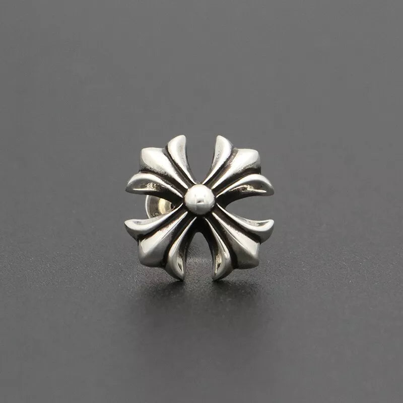 Silver floral-patterned earring on a dark gray background