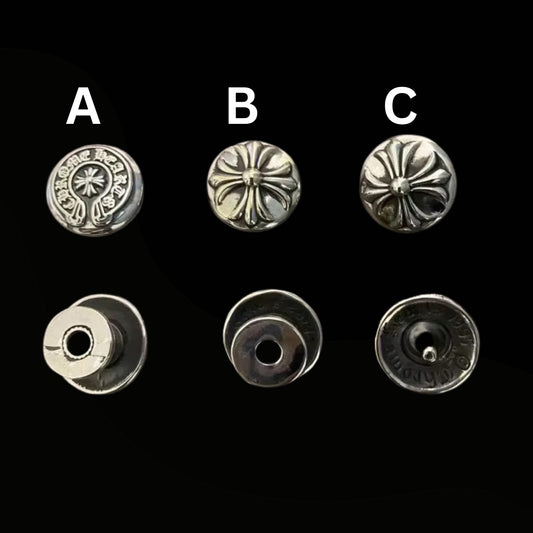 Set of six silver metal buttons with different designs on a black background