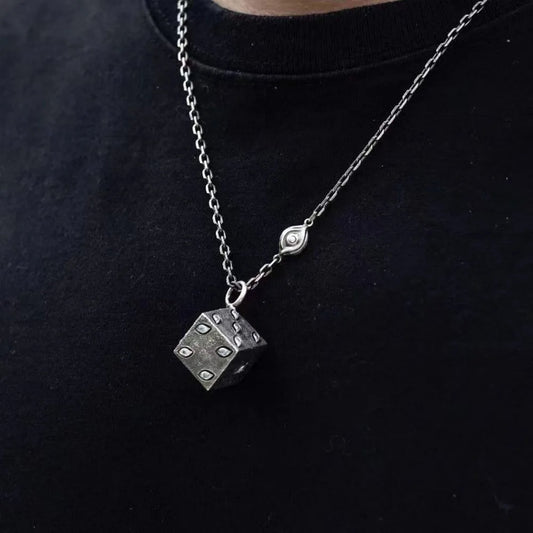 Silver necklace with a dice pendant on a black background