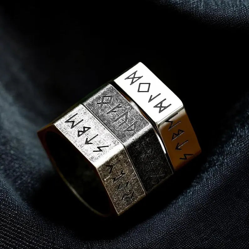 Four metallic cubes with engraved text on a dark fabric background